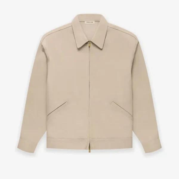 A Fear of God Taupe Zip Denim Jacket 'Dusty Beige', featuring long sleeves, a pointed collar, and two diagonal front pockets, displayed on a plain white background.