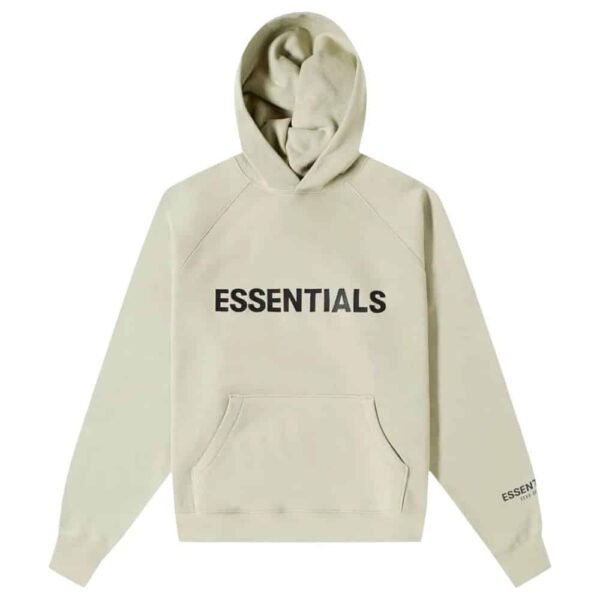 The Fear of God Essentials Sage Hoodie is a light beige hoodie with the word "ESSENTIALS" printed in bold black letters on the front. It features a front pocket and also has "ESSENTIALS" printed on the left sleeve.